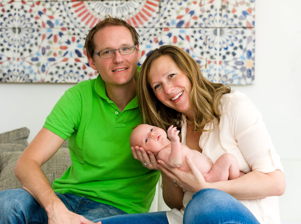Eine glückliche Familie, Mutter hält neugeborenes auf dem Arm - Newborn Fotoshooting Erlangen 