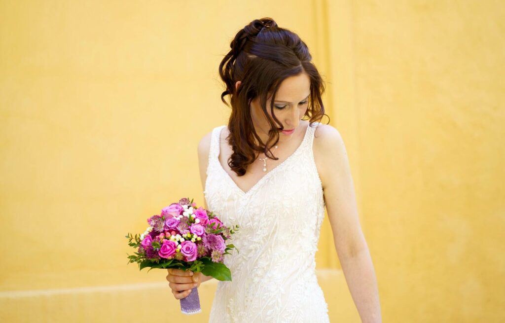 Eine wunderschöne brünette Braut mit einem pinkfarbenen Strauß Blumen in der Hand. Erlangen Hochzeitsfotos Preise.