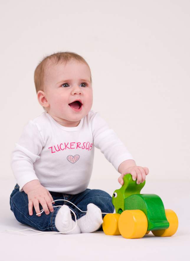 Aufgewecktes Kind mit Spielzeug aus Holz - Babyfotografie Erlangen