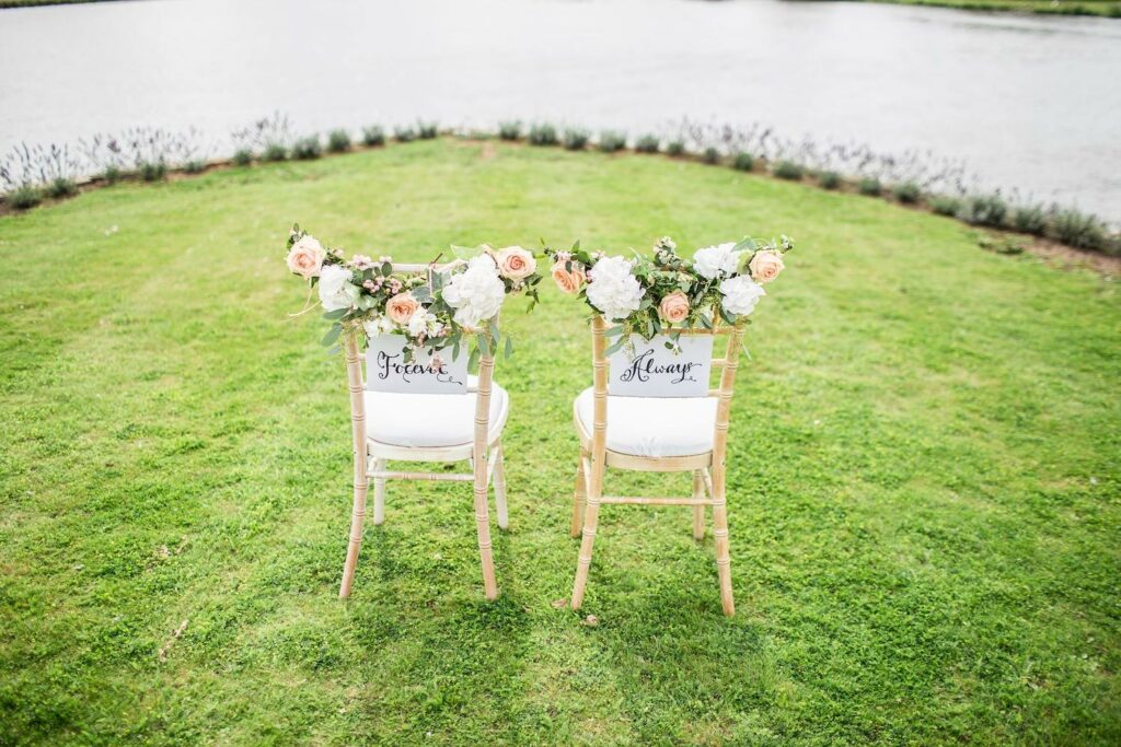 Hochzeitslocation am See mit zwei Stühlen für das Brautpaar